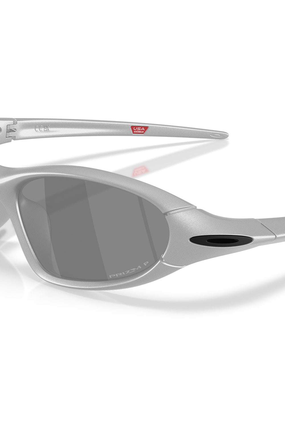 Macro close-up shot of the left lens and temple hinge on the Oakley Portal Jacket X Silver sunglasses, detailing the dark Prizm P polarized laser engraving and contrasting black ellipse logo insert.