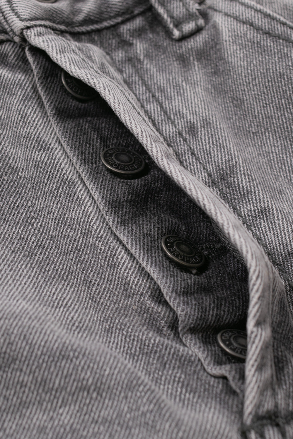 Detailed view of the open button fly closure on the Obey Boxcar Straight Leg Denim pants, showing four engraved dark metal Obey Propaganda shank buttons along the rugged grey 13.5oz washed cotton placket.