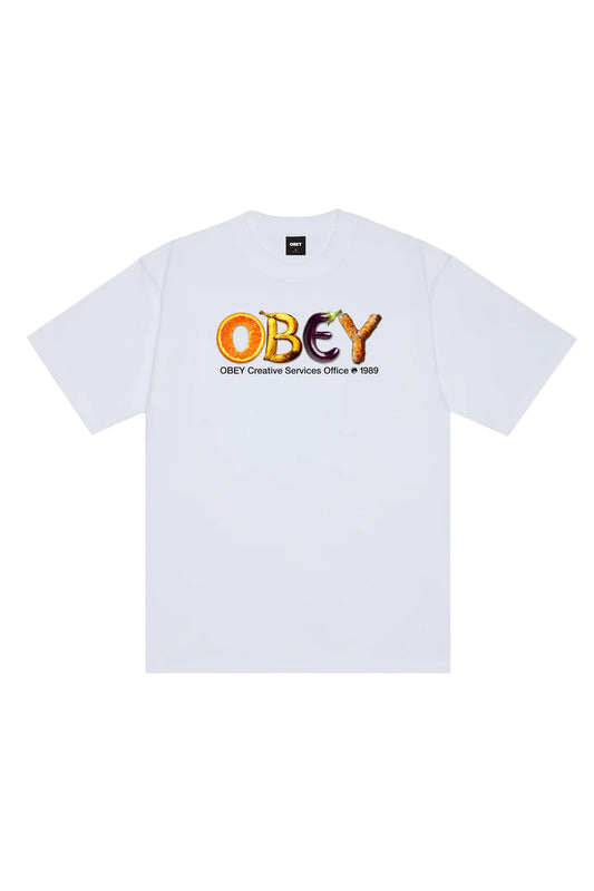 Front view of the white Obey Creative Services Office T-Shirt, made from heavy 8oz 100% cotton jersey with a loose boxy fit, displaying a colorful chest graphic featuring the letters O, B, E, and Y shaped as an orange slice, bananas, an eggplant, and a carrot root above black subtext.