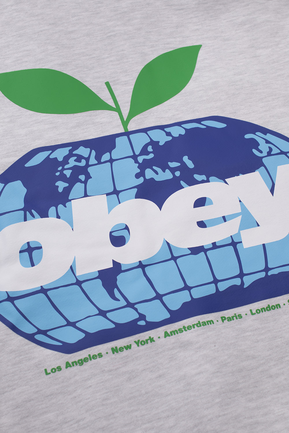 Detailed close-up shot of the multi-colored backprint on the ash grey heavy fleece Obey Intercontinental hoodie, highlighting the vibrant blue grid globe apple motif with green sprout leaves and clean white Obey branding.
