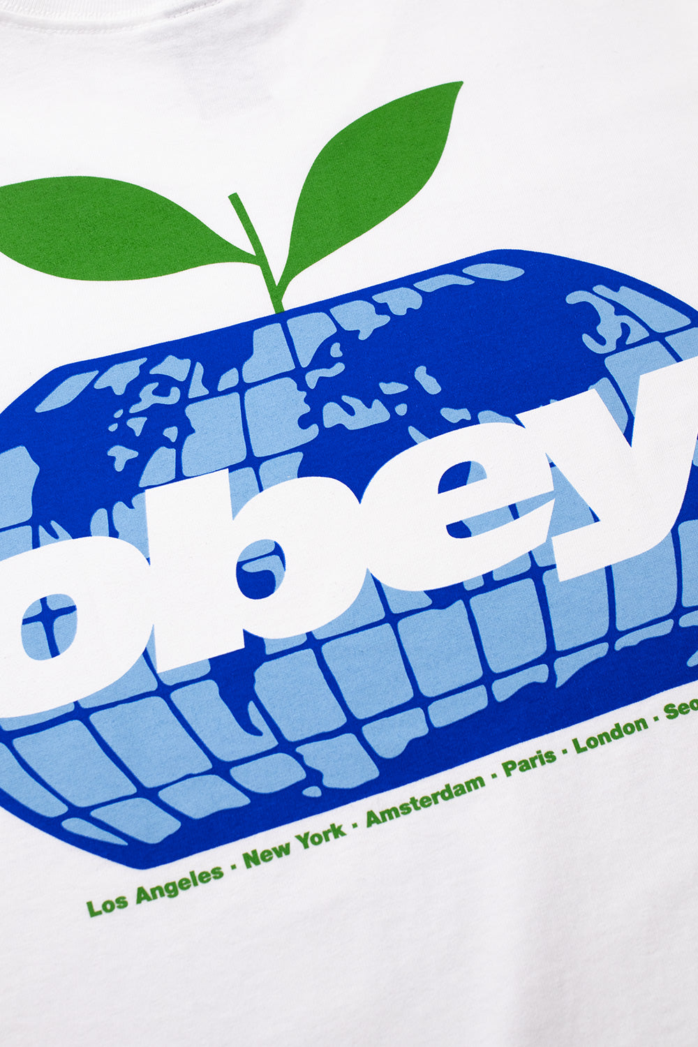 Detailed close-up shot of the multi-colored back screen print on the white Obey Intercontinental tee, highlighting the blue grid globe apple motif with green sprout leaves and bold white Obey lettering.
