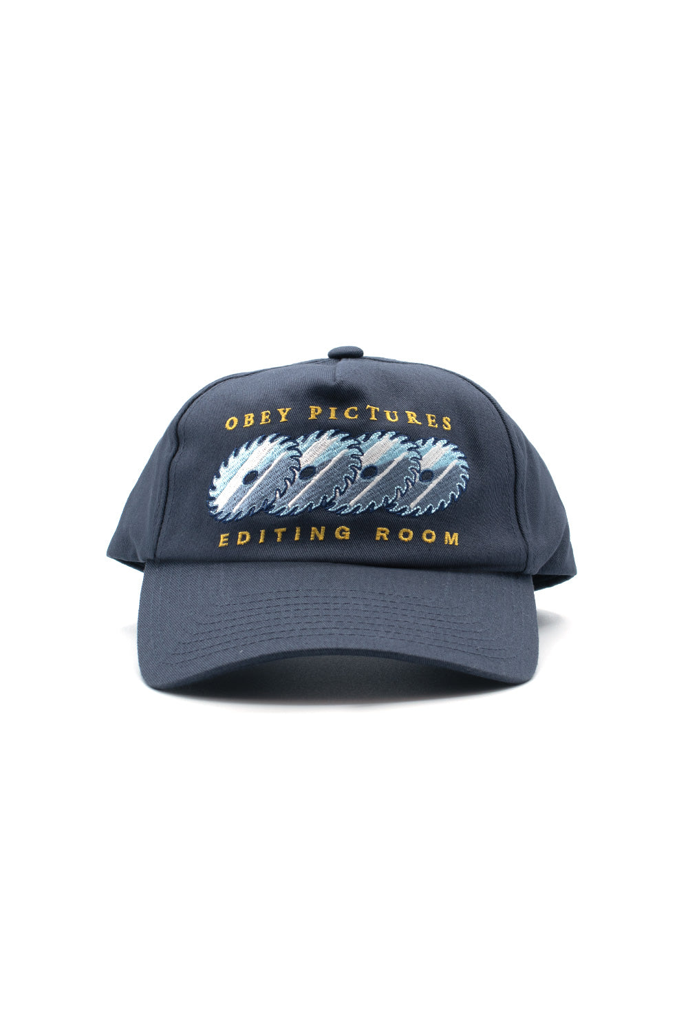 Front view of the navy blue Obey Pictures 5 Panel Snapback Cap, crafted from 100% cotton twill, showcasing a slightly curved brim, top button, and detailed multicolored embroidery on the front panel featuring repeating circular saw blades flanked by golden-yellow arched Obey Pictures and Editing Room typography.