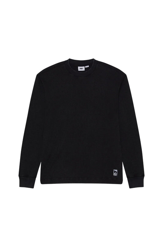 Front flat lay view of the Obey Post Thermal Longsleeve shirt in Dusty Black Limo, featuring a relaxed cut crafted from a heavyweight coarse waffle-knit cotton blend, wide ribbed crew neckline, ribbed wrist cuffs, straight bottom hem, and a square woven Obey André the Giant patch stitched above the lower left hemline.