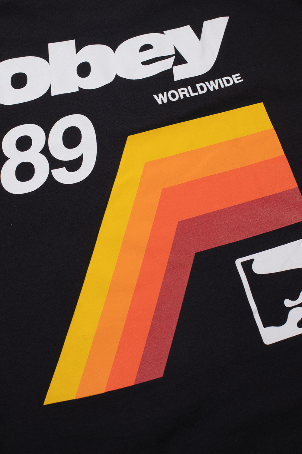 Detailed close-up shot of the multi-colored backprint on the black Obey VHS tee, showcasing the yellow, orange, and red diagonal retro cassette tape stripes alongside crisp white Obey 89 Worldwide typography and the Giant Icon graphic.