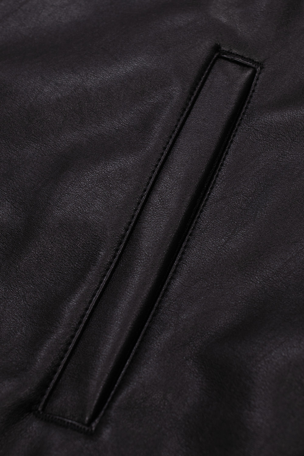 Detailed view of the reinforced angled front welt pocket on the textured black polyurethane leather shell of the Obey Workman jacket.