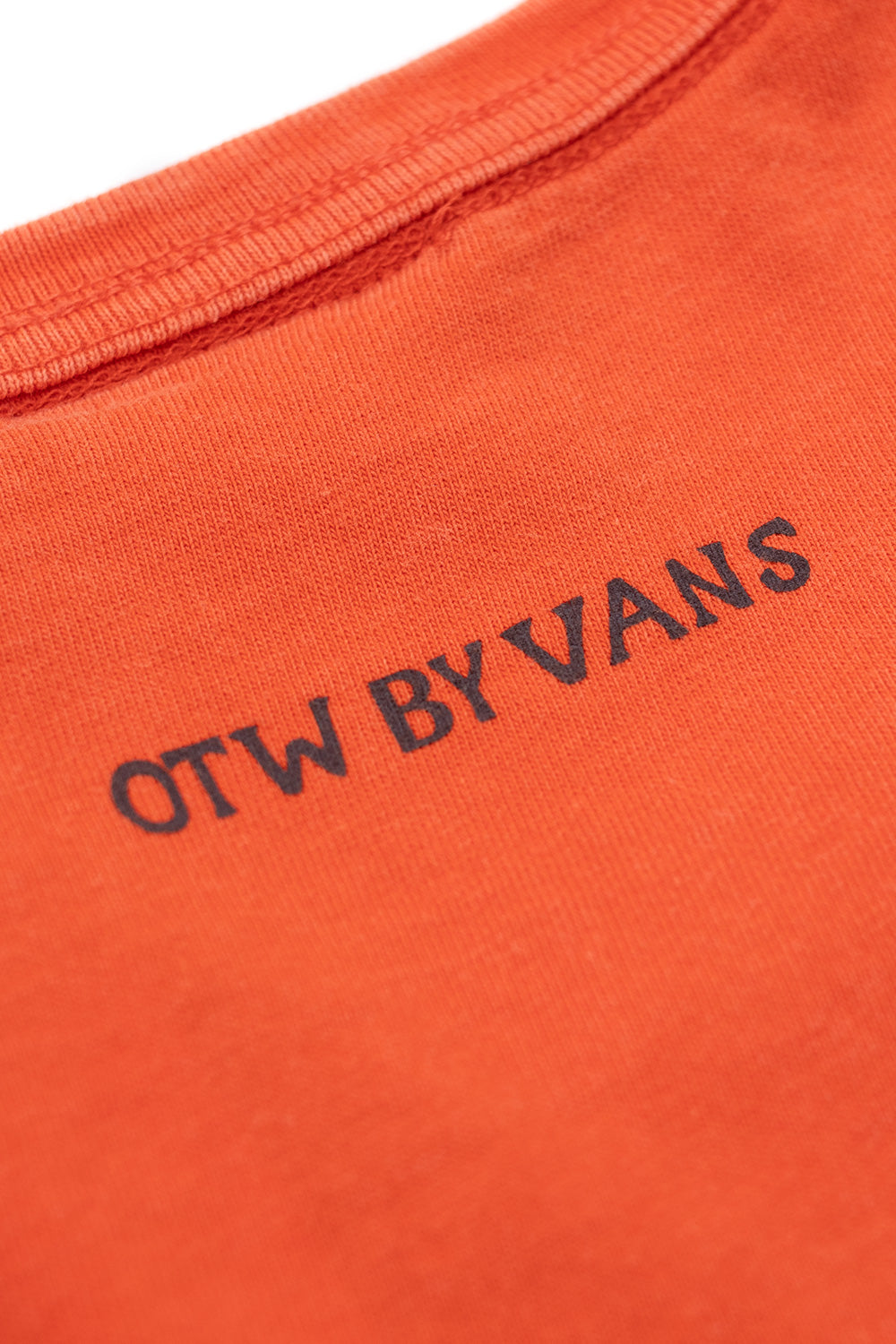 Detailed OTW by Vans back print on washed Mandarin Red cotton t-shirt showcasing clean typography, faded finish and contemporary skatewear aesthetic
