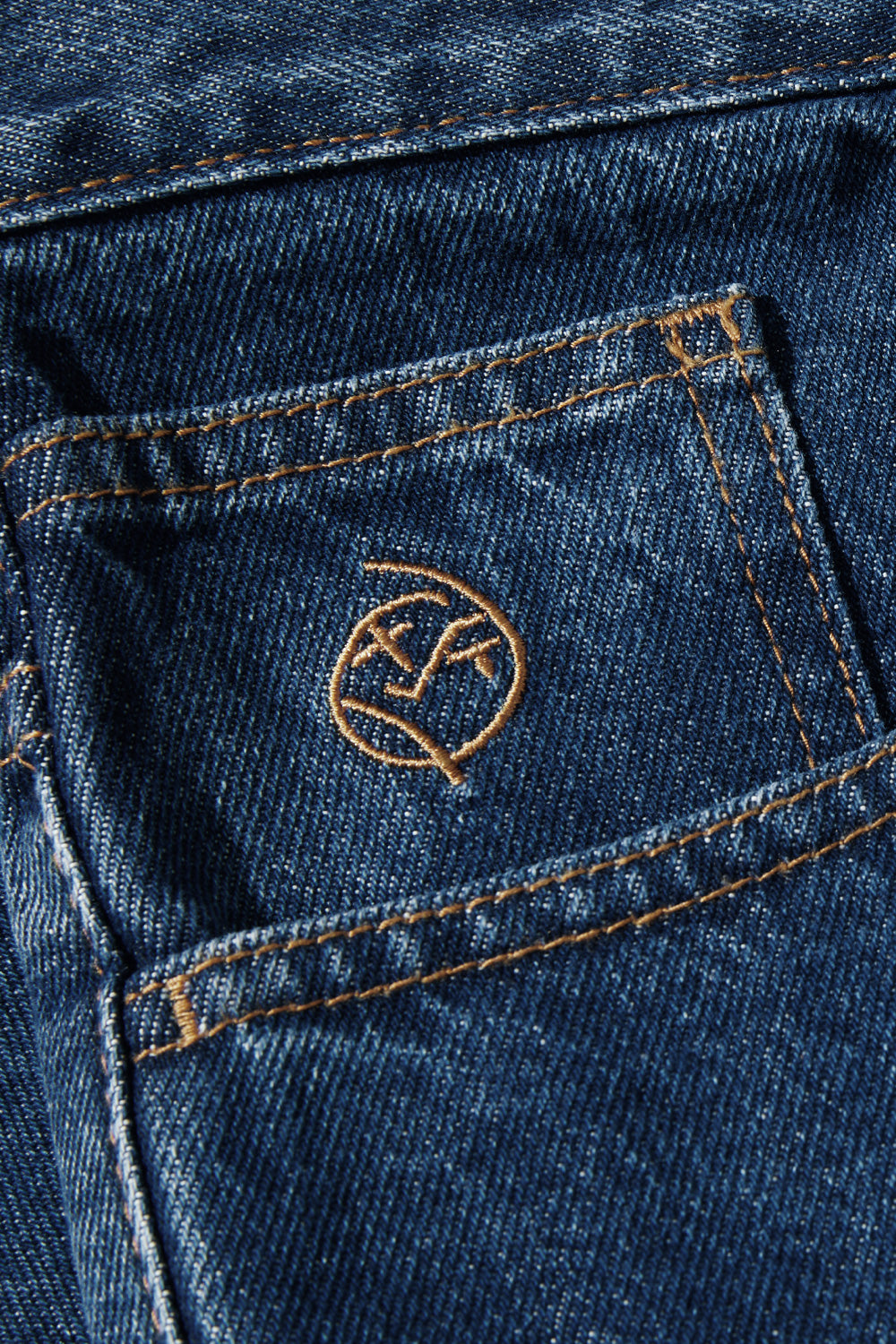 Detailansicht des gestickten Logos auf der Tasche der Polar Skate Co. Big Boy Shorts in Dunkelblau