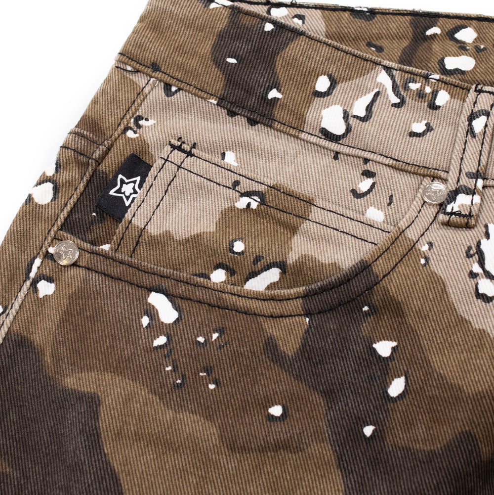 Macro studio view of the front right coin pocket on the Starteam East Village Camo Jeans, displaying silver logo rivets, reinforced double-track edge stitching, and a square black woven label featuring a white embroidered star silhouette set against the speckled pebble camouflage pattern.