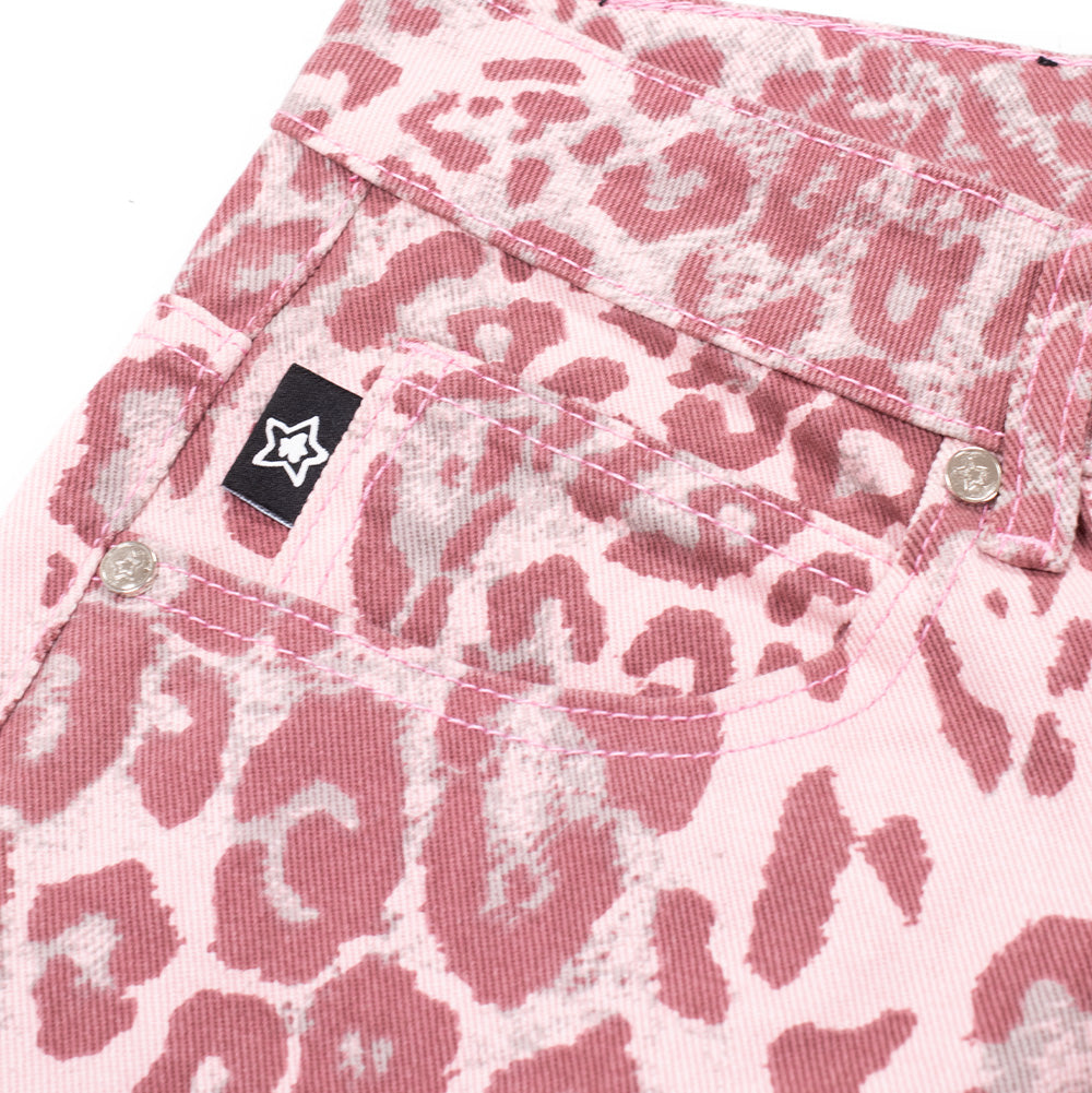Macro studio view of the front right coin pocket on the pink Starteam East Village Jeans, displaying silver-tone rim rivets, clean double-track tonal pink stitching, and a small woven black tab bearing an embroidered white five-pointed star set against the bleached pink leopard rosette print.