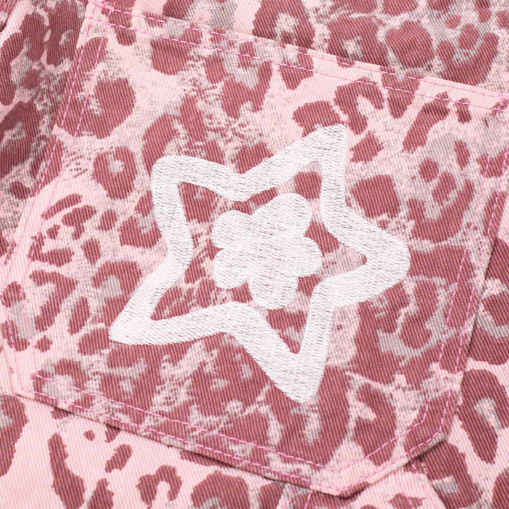 Detailed close-up shot of the rear right pocket embroidery on the Starteam East Village Leopard Star Jeans, focusing on the heavy, textured white chain-stitch embroidery depicting a five-pointed star with an interior floral petal center over the dynamic pink-and-white leopard pattern.