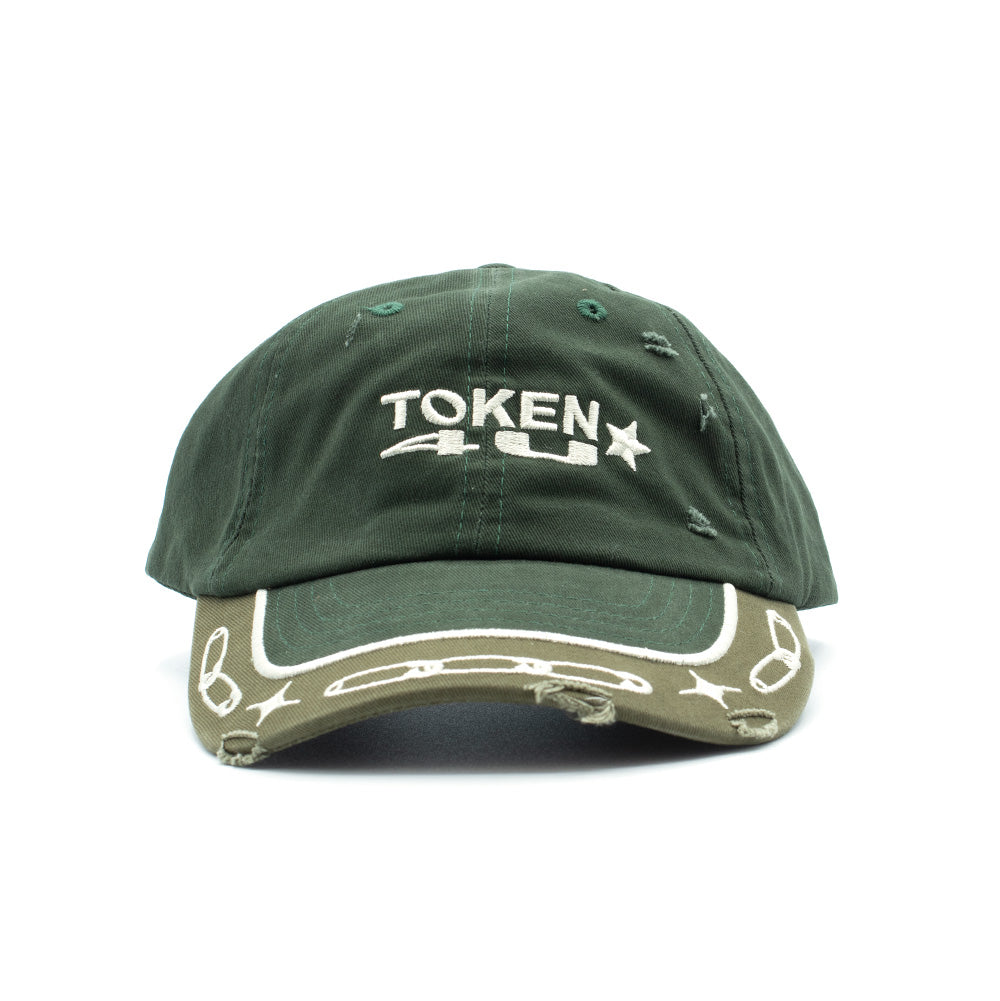 Front studio view of the two-tone Token Lowkey Cap in midnight green, showcasing an unstructured six-panel cotton dad cap crown with subtle distressed fraying, bold white 3D satin-stitched "TOKEN 4U" lettering with a star icon across the front, paired with an olive green curved brim featuring white embroidered safety pins, sparkle stars, and a distressed edge cut.