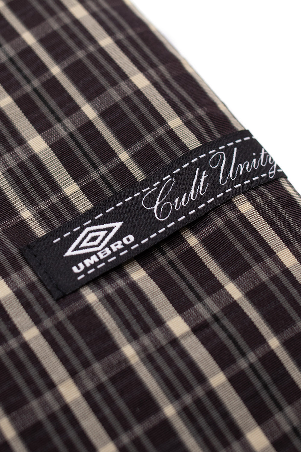 Woven Cult Unity x Umbro label on check smock anorak beige dark brown, Italian-made streetwear jacket branding detail