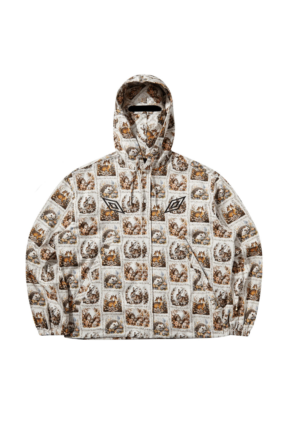Front flat lay view of the Umbro Cub Masked Shirt in ivory, showcasing a boxy zip-and-button hooded jacket cut covered in a vintage tapestry-style floral print with woodland animals like deer, rabbits, hedgehogs, and squirrels, featuring elasticated cuffs, side pockets, black embroidered Umbro double diamond logos, and an integrated hood mask with a horizontal eye slit