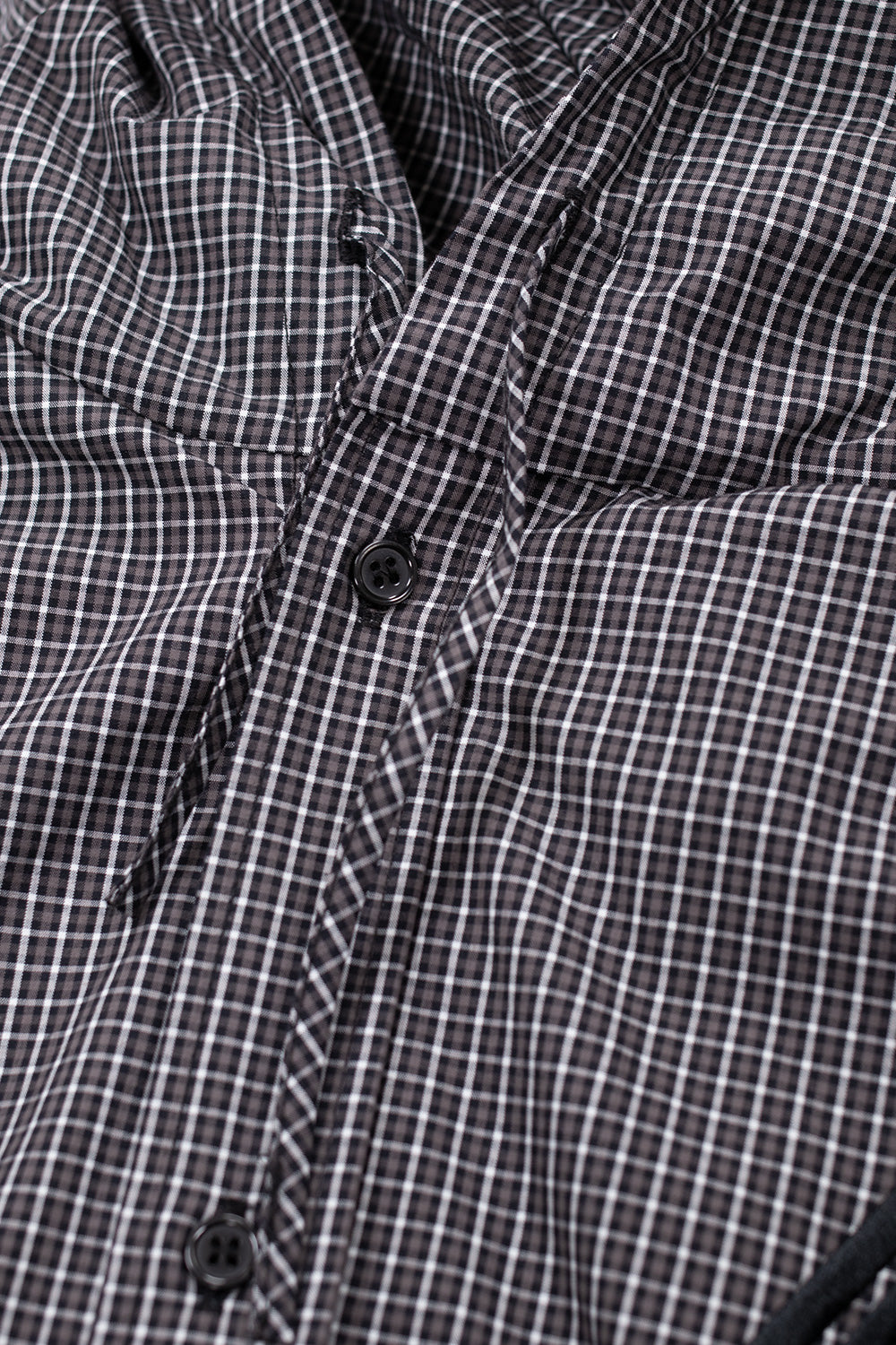 Close-up detail of Umbro Gingham Masked Shirt fabric in coffee brown and white, featuring fine cotton gingham check texture and premium construction inspired by British tailoring heritage.