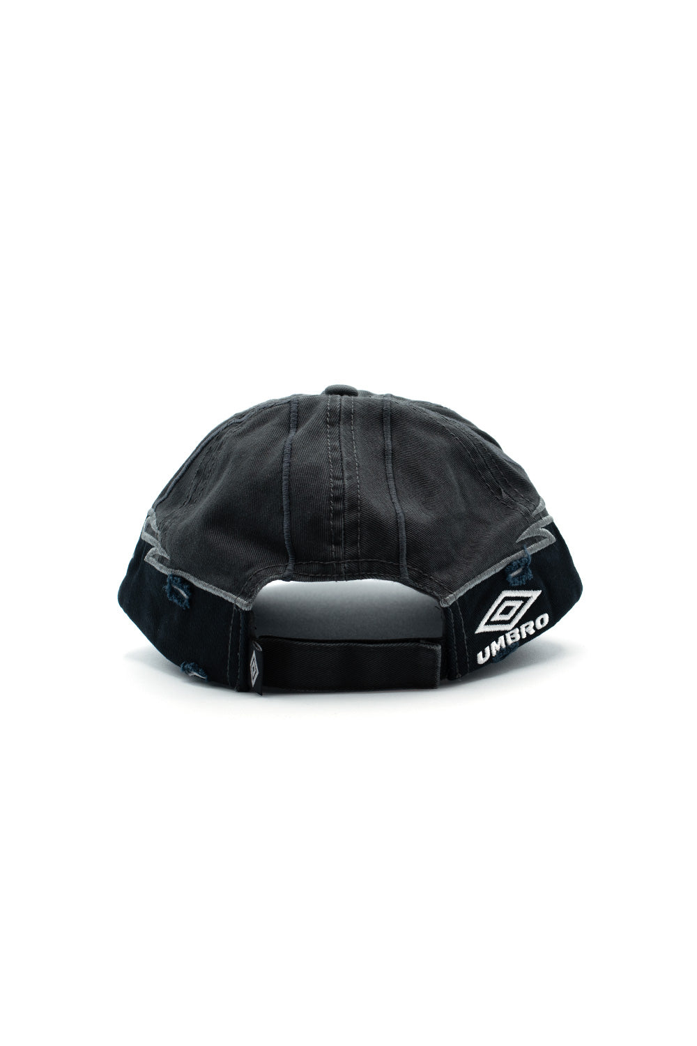 Rear perspective view of the Umbro Goalkeeper Cap, highlighting the washed charcoal crown fabric, distressed rips at the panel hems, open arch cut-out, adjustable black Velcro strap closure, and a prominent white embroidered Umbro double diamond logo on the right rear panel