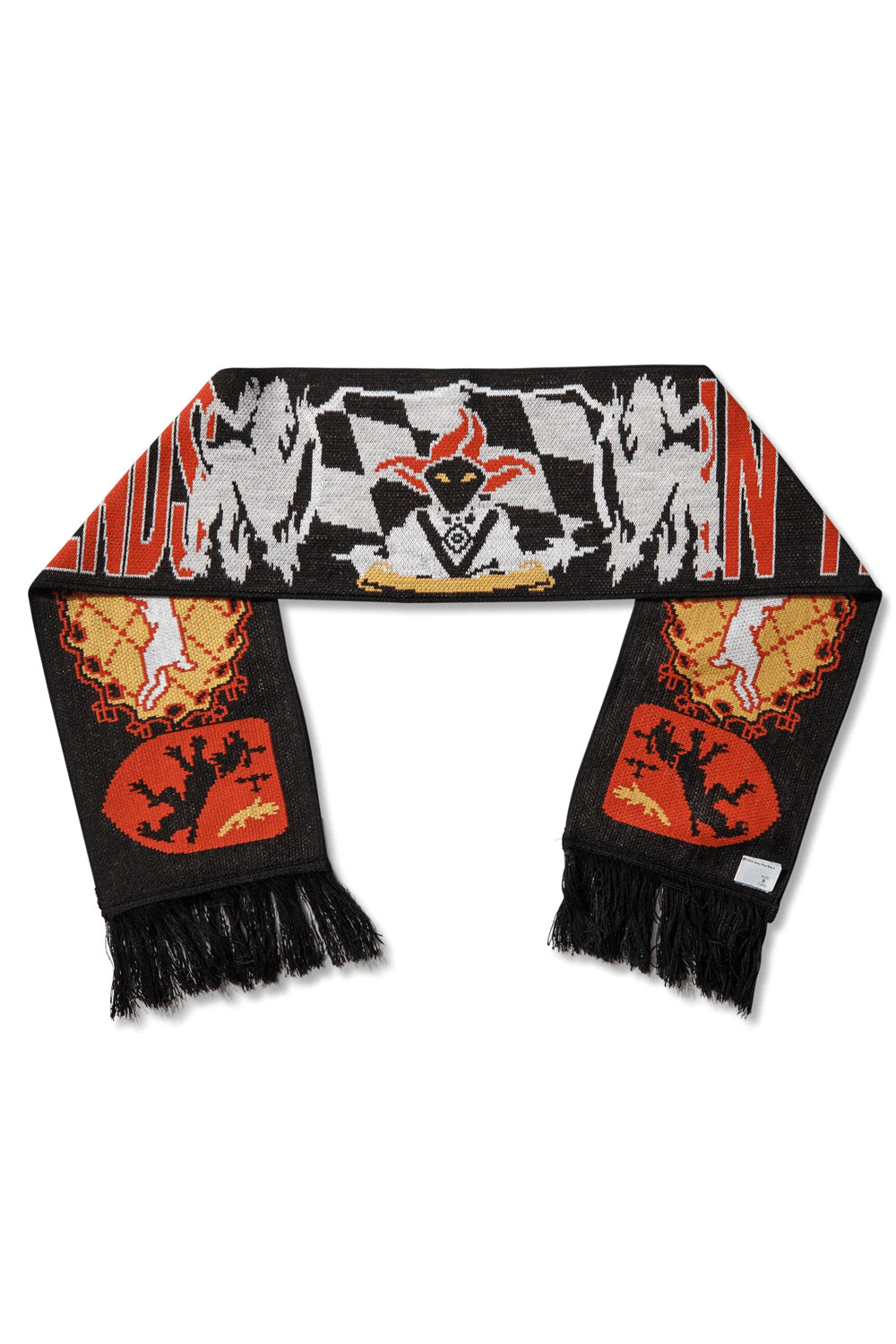 Full flat lay overview of the Umbro It All Ends In Tears Scarf measuring roughly 133 by 20 cm, made in Italy from 100% black acrylic jacquard knit, showcasing black fringe ends, red shield emblems with rampant lions, circular gold sunburst heraldic crests, and a central jester character positioned over a grey-and-white checkered flag banner with bold red blocked lettering