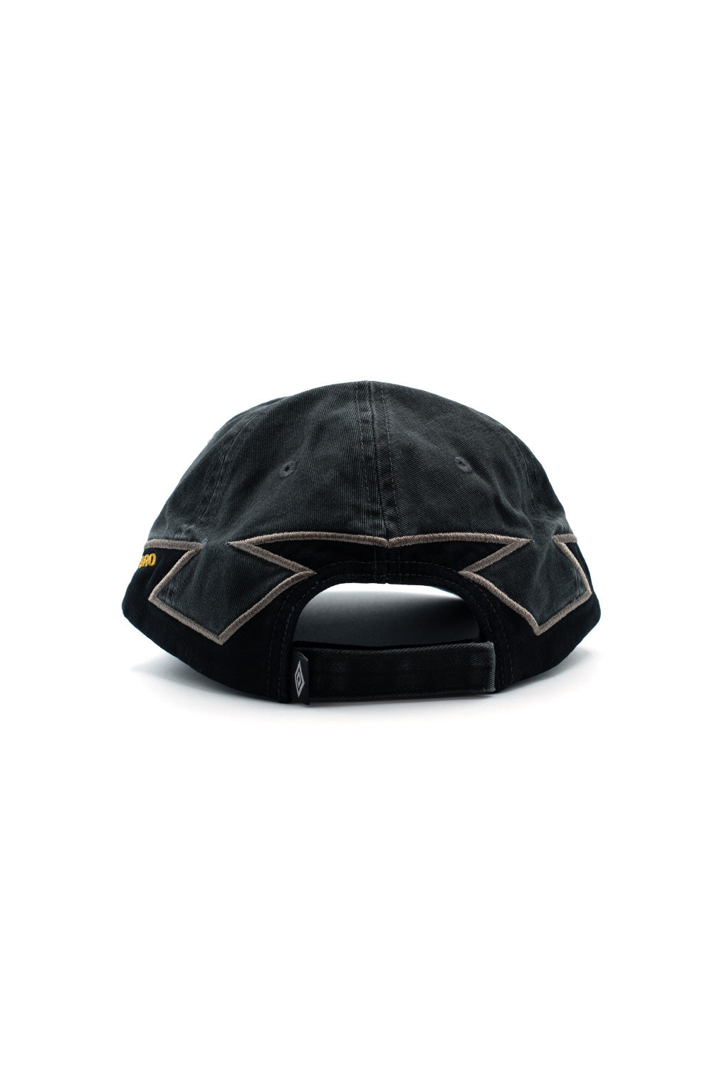 Rear perspective view of the Umbro Laurel Cap in dark green, displaying the embroidered eyelets, structured arch cut-out, adjustable matching cotton Velcro strap closure, folded mini diamond tag, and bold angular taupe edge embroidery tracing across the lower rear panels