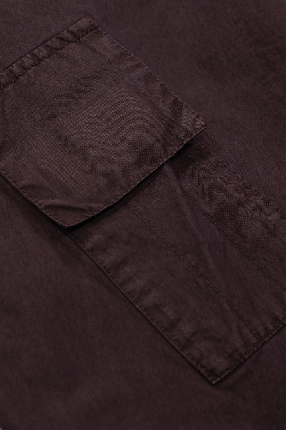 Macro close-up view of the auxiliary utility cargo pocket situated on the upper sleeve of the Umbro Midfield Jacket, featuring a fold-over rectangular flap, concealed fastening, and neat edge topstitching