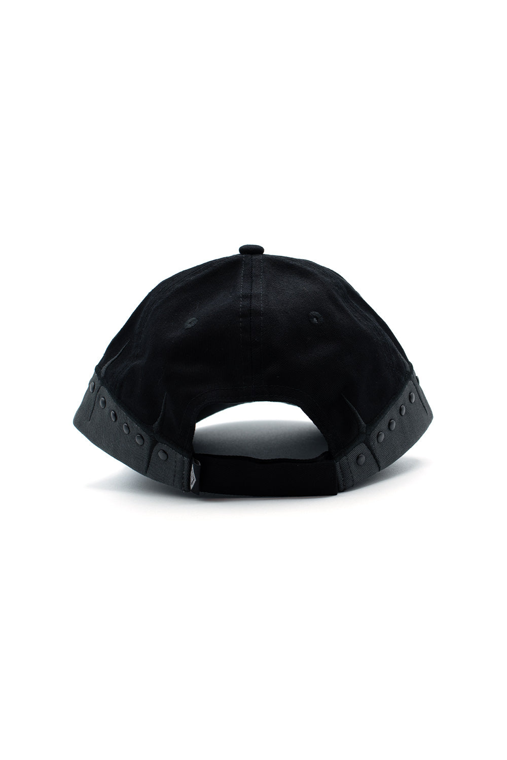 Rear perspective view of the Umbro Spikes Stud Cap, showcasing the clean unconstructed cotton crown, dark grey base trim running along the rim set with matte metallic studs, open semicircular cut-out arch, and an adjustable black cotton strap equipped with a secure Velcro closure
