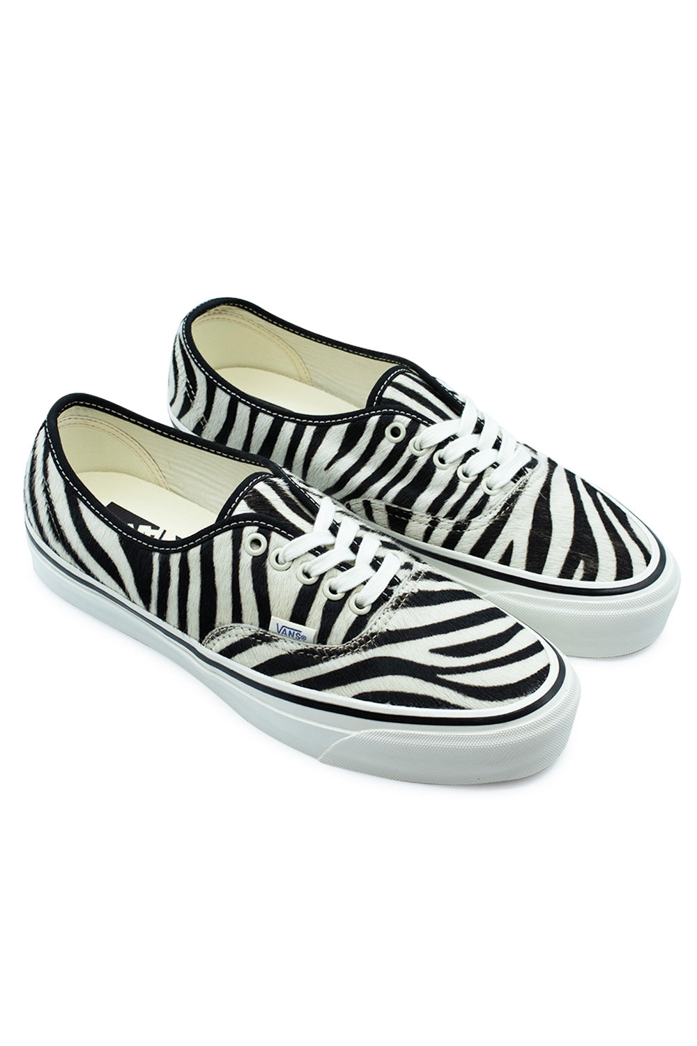 Three-quarter perspective studio shot of the Vans LX Authentic 44 Zebra / Marshmallow shoes, highlighting the 70s punk-inspired animal texture, glossy marshmallow-colored vulcanized foxing tape, and vintage low-top skate silhouette.