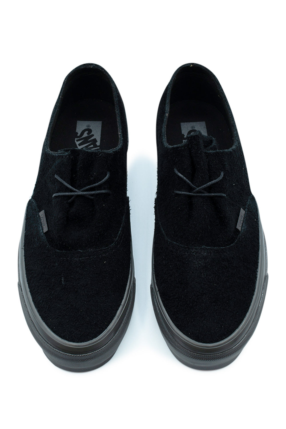 Top-down perspective of a pair of monochrome Vans LX Authentic Ease low-top shoes, displaying the raw hairy suede vamp, ultra-clean two-eyelet lace closure, slim black string laces, and black insoles printed with classic Vans branding.