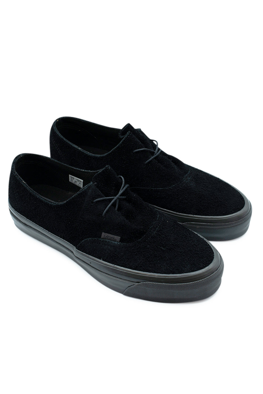 Three-quarter perspective studio shot of the all-black Vans LX Authentic Ease sneakers, showcasing the deconstructed low-profile silhouette, rich tactile hairy suede texture, and continuous dark midsole.