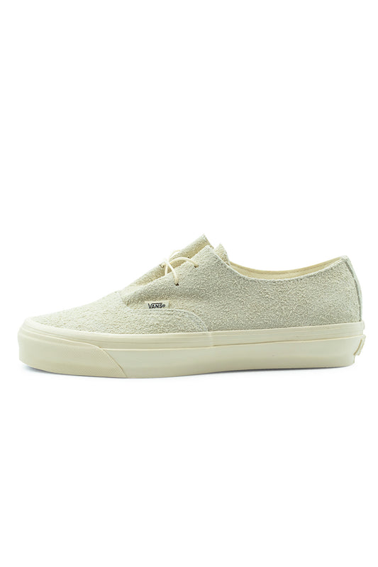 Lateral side profile view of the Vans LX Authentic Ease sneaker in Hairy Suede Sand, featuring a rough-textured cream sand suede upper, streamlined two-eyelet thin lacing, a small white Vans woven tab, and a solid cream vulcanized midsole.