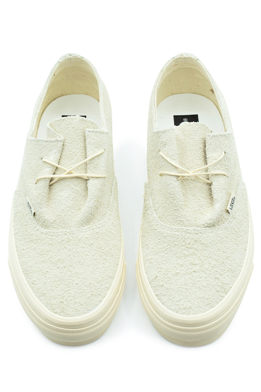 Top-down perspective of a pair of Vans LX Authentic Ease low-top shoes in Hairy Suede Sand, highlighting the minimalist two-eyelet lace setup, thin cream string laces, raw hairy suede vamp, and white insoles with printed branding.