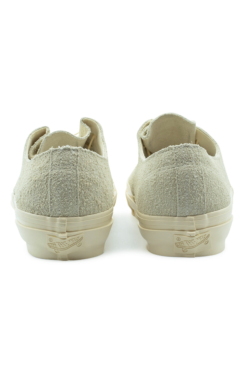 Rear view of the heels of the Vans LX Authentic Ease Hairy Suede Sand shoes, displaying the textured sand suede heel counter with raw-edge stitching and tonal monochrome Off The Wall license plate patches on the cream foxing tape.