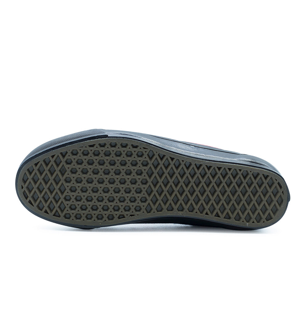 Full bottom studio flat lay of the Vans LX Old Skool vulcanized rubber outsole, featuring the signature dark gum waffle traction tread pattern framed by glossy black textured sidewalls and a knurled toe bumper for optimal skateboard grip.