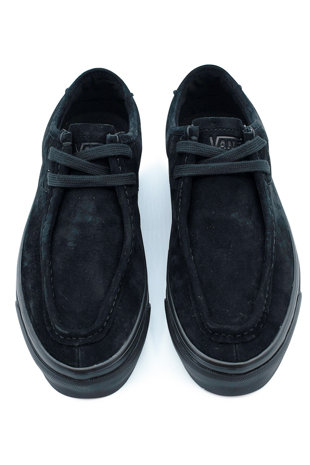Top-down view of a pair of Vans LX SF Moc Low shoes in all-black, displaying the textured suede uppers with raised moc-toe seam construction, tonal black flat laces, and short suede tongues debossed with clean Vans logo lettering.
