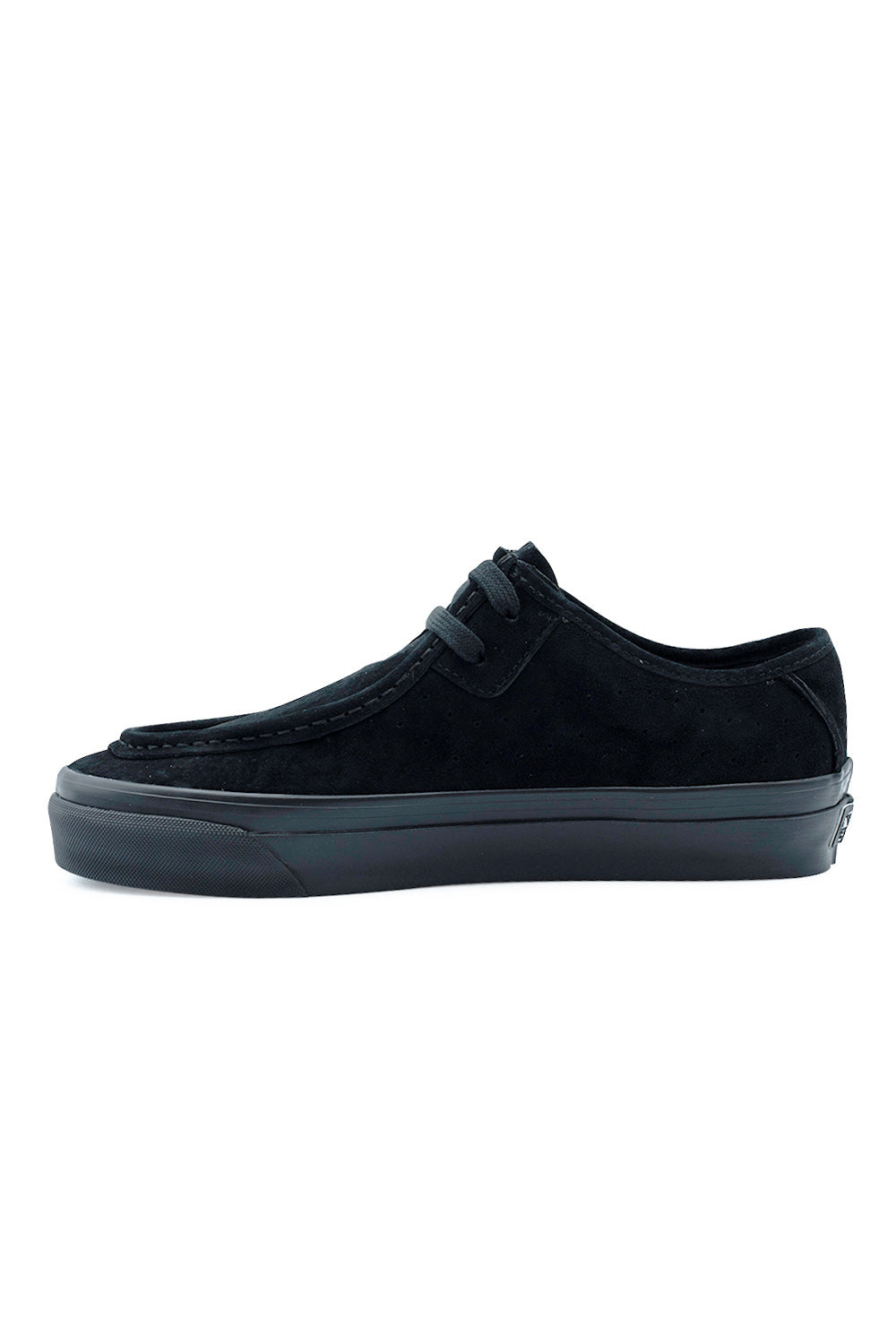 Medial arch view of the Vans LX SF Moc Low shoe in black suede, showing the refined moc-toe stitch line running along the vamp, perforated ventilation holes across the midfoot panel, and durable black rubber foxing tape.