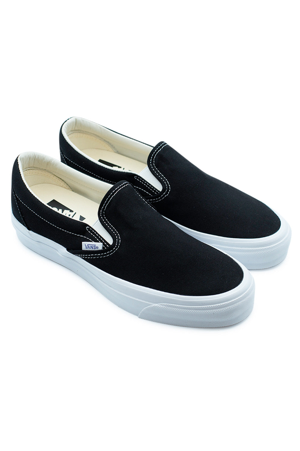 Vans LX Slip-On Reissue 98 Black White skate sneakers angled pair view highlighting low-profile Style 98 design, durable canvas upper and timeless Vans streetwear silhouette