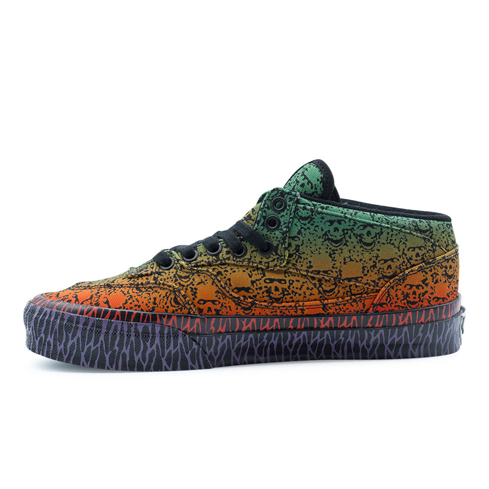 Medial side profile studio view of the Vans OTW x Chito Half Cab 33 shoe, showing the clean inner canvas panel with seamless skull art and green-to-orange gradient shading, reinforced arch stitching, black metal eyelets, and the full run of red and violet tribal barbed linework wrapping the high vulcanized rubber midsole.