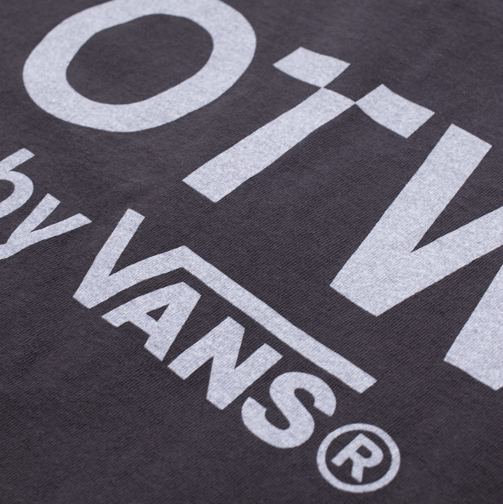 Close-up shot of the back typography on the washed black Vans OTW x Chito T-Shirt, detailing the clean, cracked-finish white screen-printed ink of the "OTW by VANS" branding against the textured weave of the heavyweight cotton jersey.