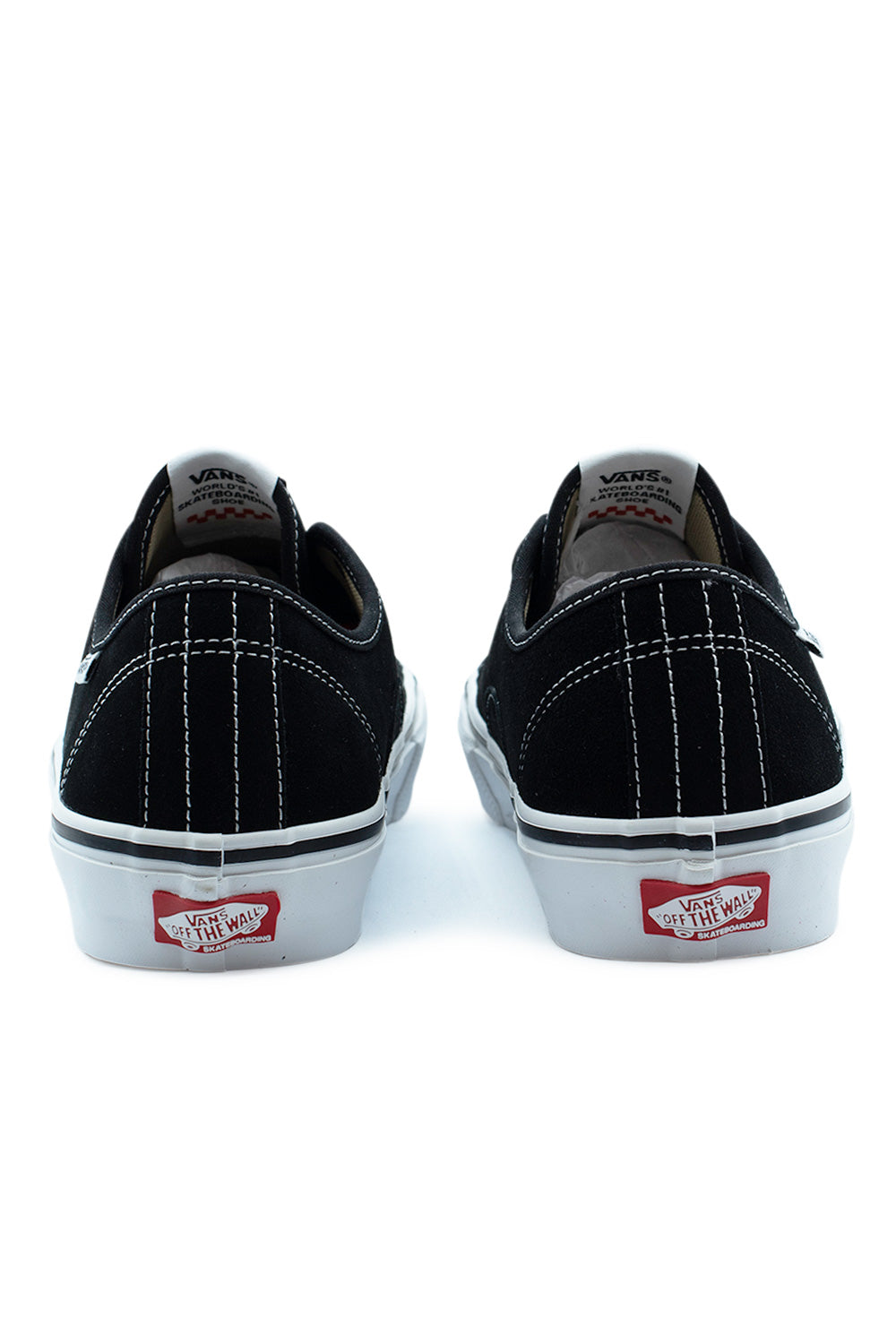 Rear view of the heels of the Vans Skate AVE Classic Black / White shoes, displaying the white vertical seam stitching on the black suede heel counter and red Vans Off The Wall Skateboarding rubber heel license plate tags.