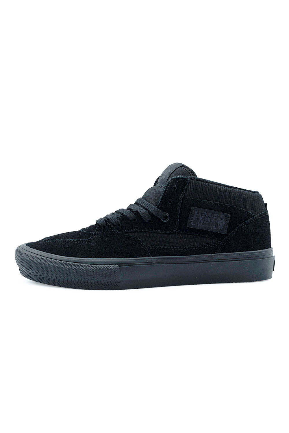 Lateral profile view of the Vans Skate Half Cab shoe in Black / Black, showcasing the monochromatic black suede overlays and heavy-duty canvas underlays, padded mid-top ankle collar, tonal black Half Cab woven heritage patch, flat laces, and a matching black vulcanized midsole with textured toe knurling.