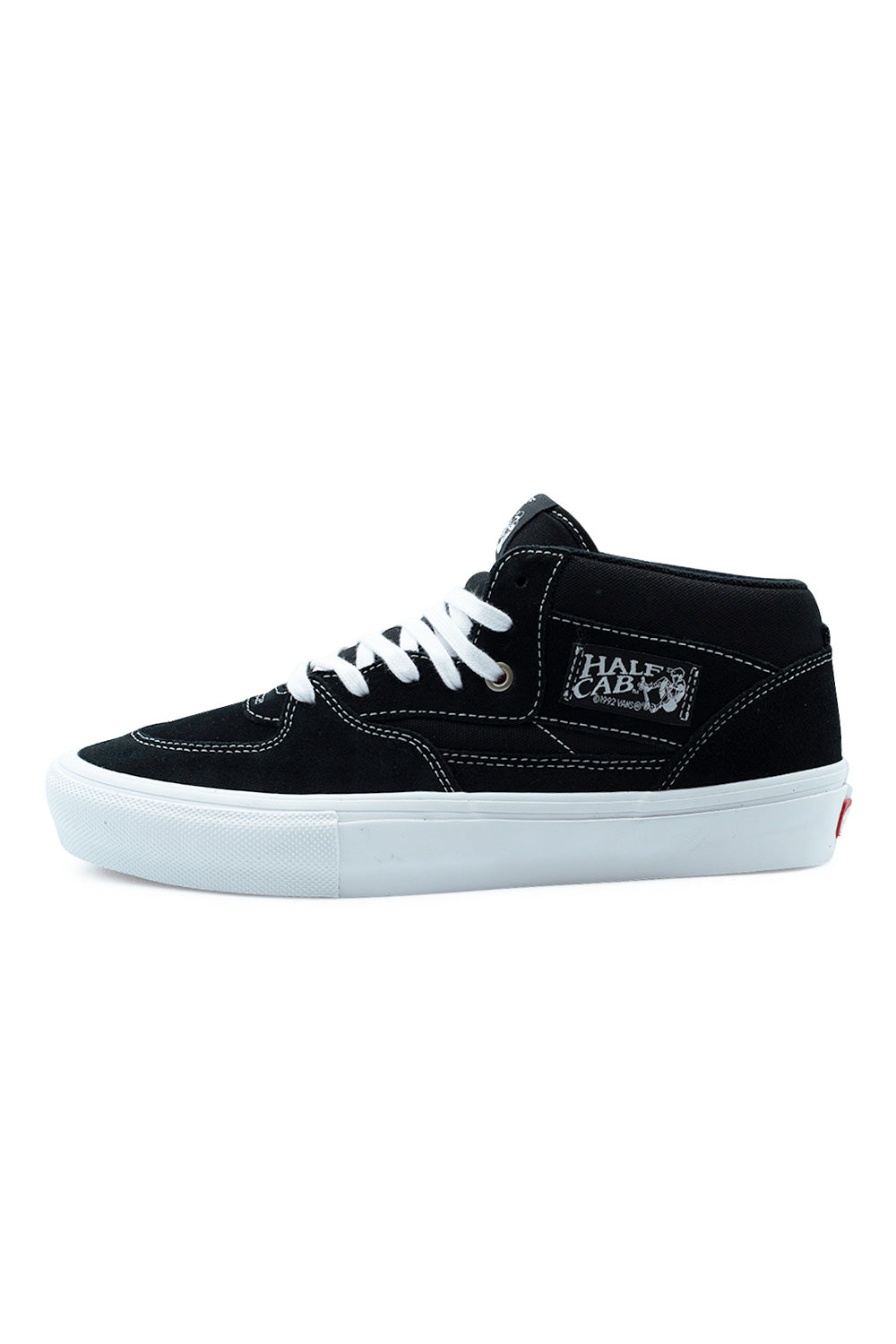 Lateral profile view of the Vans Skate Half Cab shoe in Black / White, featuring durable black suede overlays with crisp white contrast stitching, heavy canvas quarter panels, clean white flat laces through silver eyelets, the woven Half Cab Steve Caballero side patch, and a solid white vulcanized midsole with a textured front bumper.