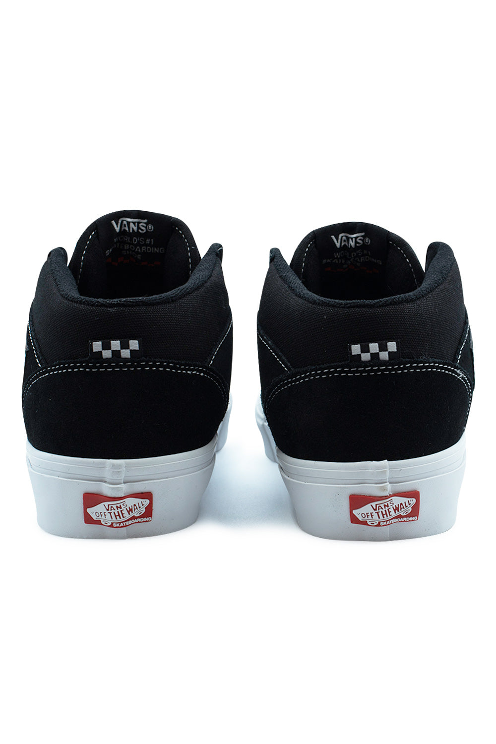 Rear view of the heels of the Vans Skate Half Cab sneakers in Black / White, highlighting the padded mid-top collars, subtle black-and-grey checkerboard flag tags, vertical black suede heel counters with white stitch accents, and red rubber Vans Skateboarding Off The Wall license plates set into the white foxing tape.