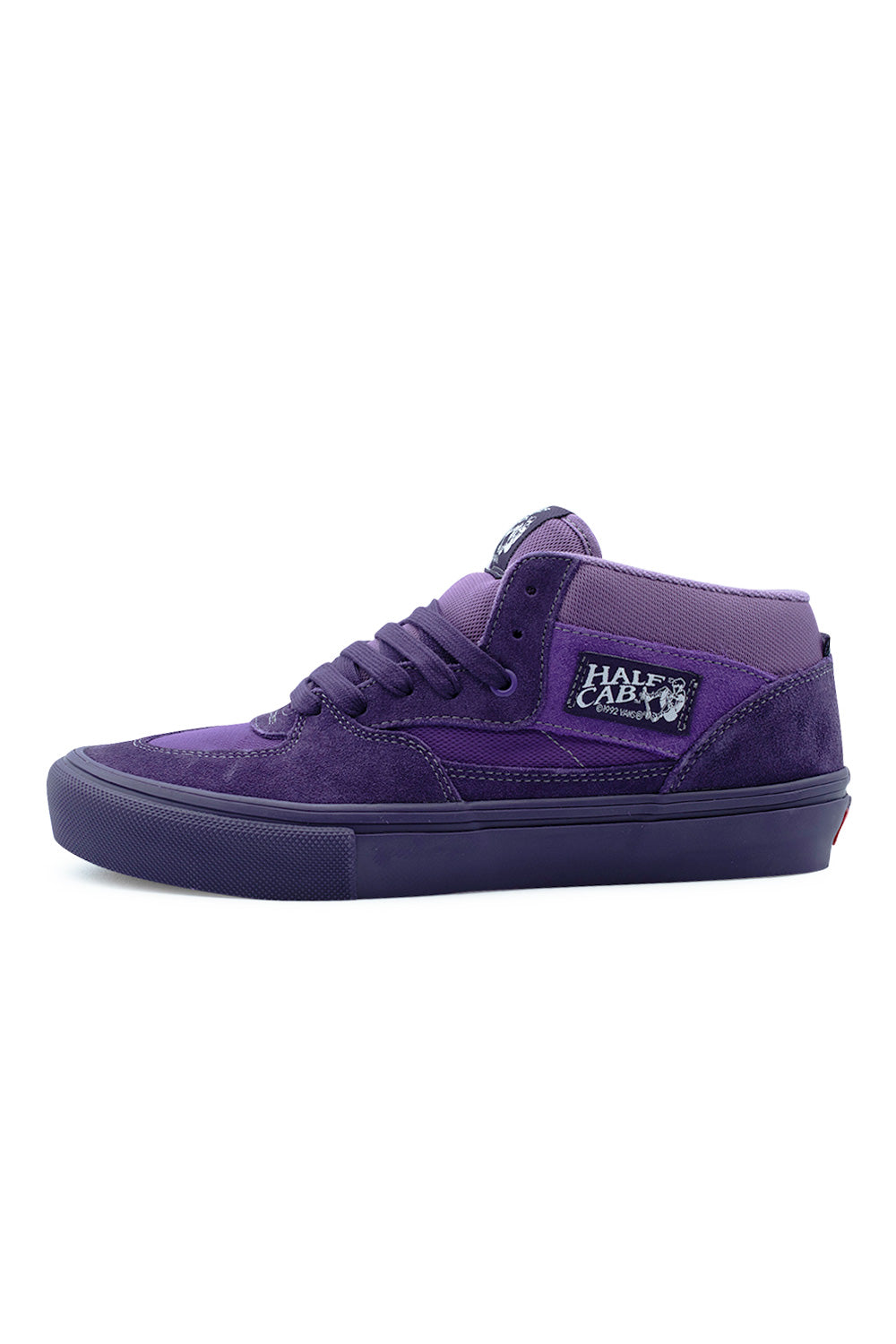 Lateral profile view of the Vans Skate Half Cab shoe in Purple Licorice, showcasing the deep purple suede overlays and mesh underlays, padded mid-top ankle collar, woven Half Cab heritage logo patch, tonal flat laces, and a matching tonal purple vulcanized rubber foxing midsole with knurled toe bumper.