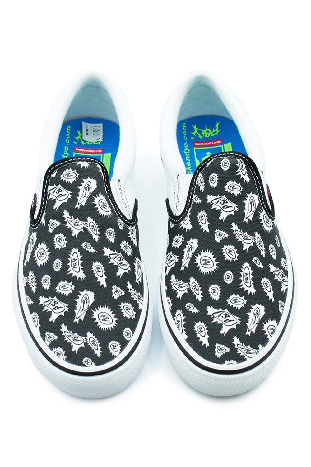 Top-down studio view of a pair of Vans X Punk And Yo Skate Slip-On shoes, highlighting the black canvas vamp panels decorated with Montreal skate-brand Punk and Yo spiked sunburst emblems, white contrast stitching, padded white leather collars, and bright electric blue PopCush insoles with neon green branding