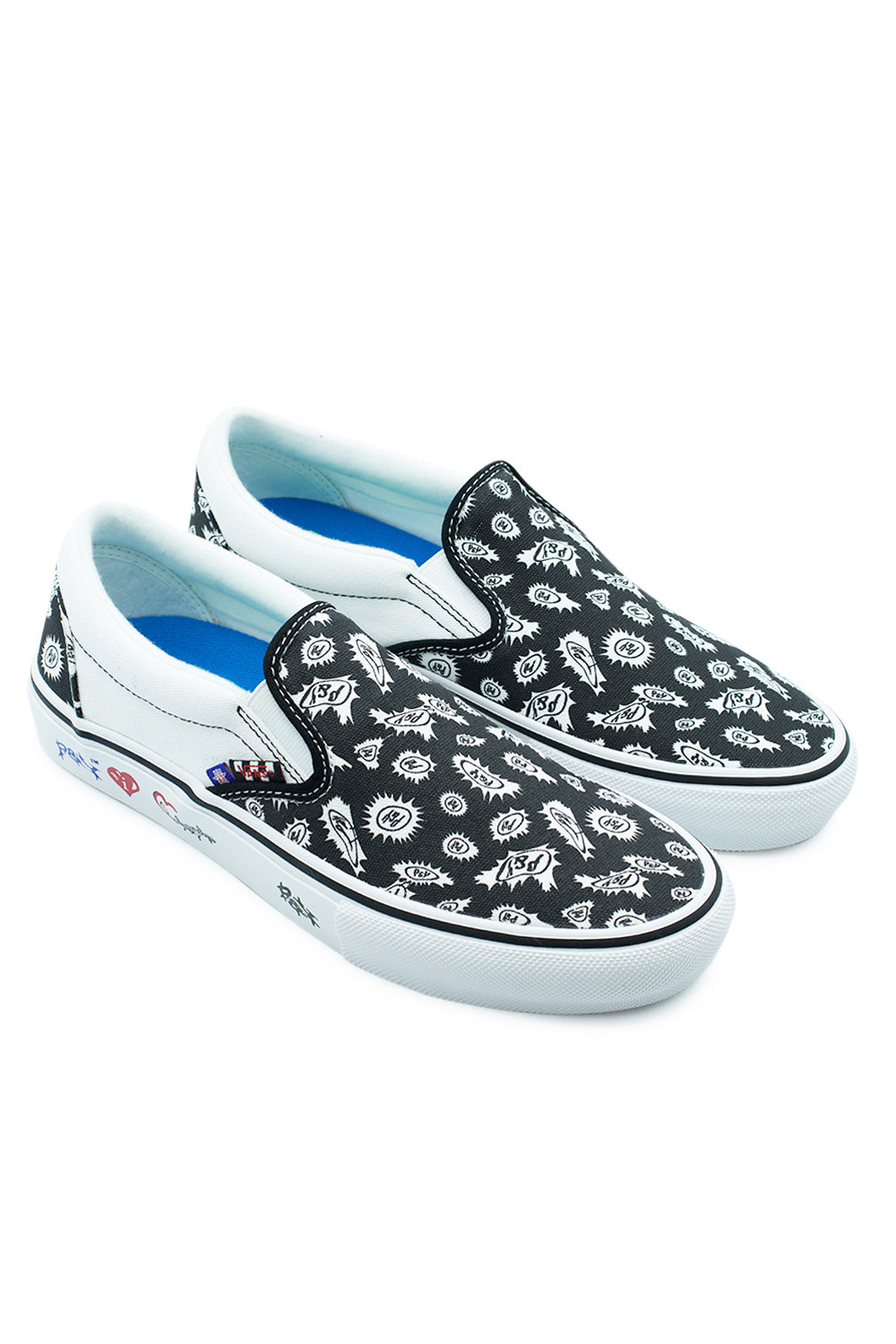 Angled three-quarter studio view of the Vans X Punk And Yo Skate Slip-On shoes, showcasing the low-profile skate slip-on silhouette, bold graphic bandana pattern on the forefoot, bright blue cushioned footbeds, and vulcanized white rubber midsoles detailed with graffiti-style branding