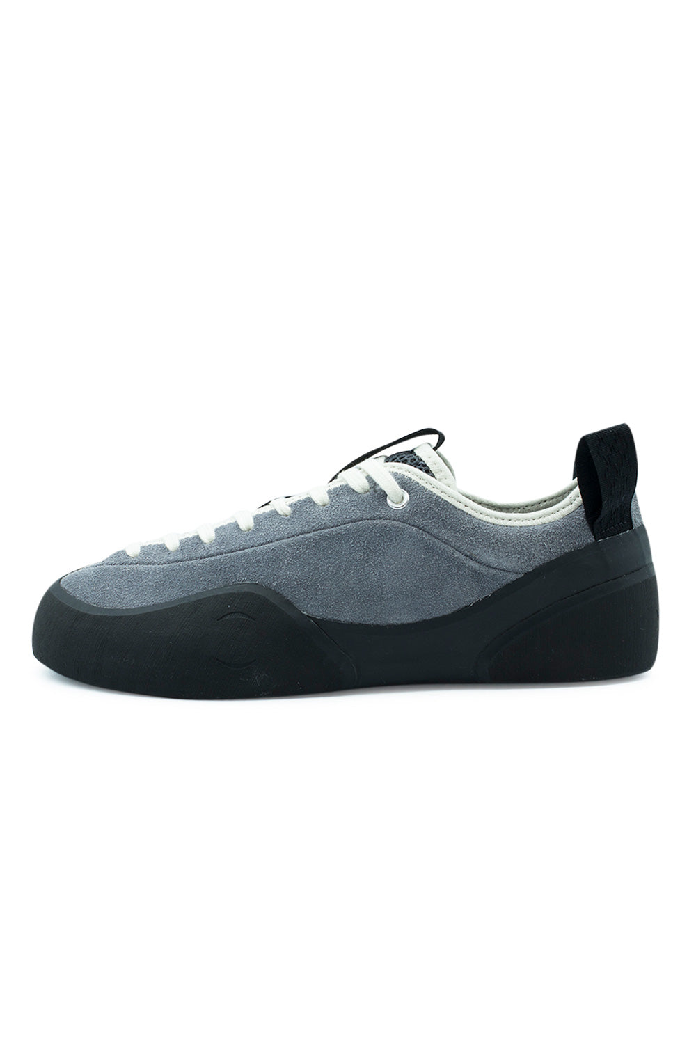 Lateral profile view of the Village PM 1PM skate shoe in Grey and Natural Black, featuring a low-cut premium grey suede upper, climbing-inspired hand-wrapped black sticky rubber rand enveloping the forefoot and ollie guard zone, white eyelets, off-white flat laces, and an oversized black heel pull tab[cite: 89].