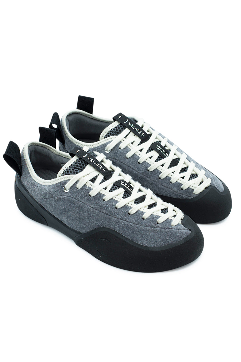 Elevated three-quarter studio angle of the Village PM 1PM shoe in Grey / Natural Black, highlighting the technical hybrid of rock climbing approach shoe utility and functional skateboard footwear construction with deep front toe rubber coverage[cite: 92].