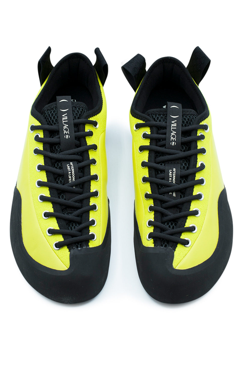Top-down studio shot of a pair of Village PM 1PM Lime LTR shoes, displaying the anatomical asymmetrical foot silhouette, protective matte black climbing rubber toe bumpers, extended full-foot black lacing system through silver metal eyelets, black breathable spacer mesh tongues, and branded woven "VILLAGE PM" pull ribbons.