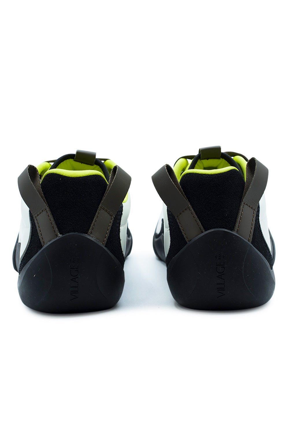 Rear perspective shot of the heels of the Village PM 2PM sneakers, displaying the high-wrapped natural black climbing rubber heel cups embossed with vertical "VILLAGE" branding, black suede heel collars, bright neon lime interior lining, and dual heavy-duty olive webbing pull loops angled outward.