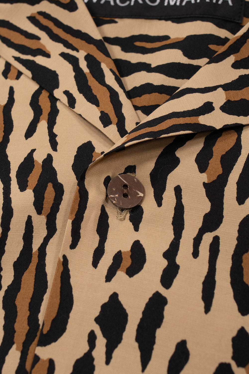 Close-up detail of the camp collar and the top wooden button on the brown Wacko Maria rayon Hawaiian shirt.