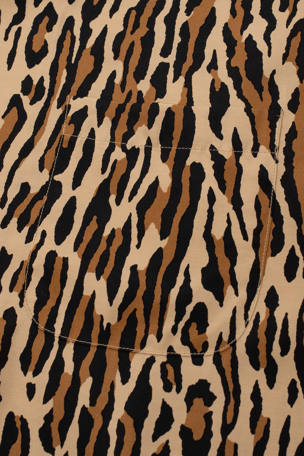 Detailed shot of the left chest pocket on the brown Wacko Maria shirt, showing how the leopard animal print pattern seamlessly aligns with the body fabric.