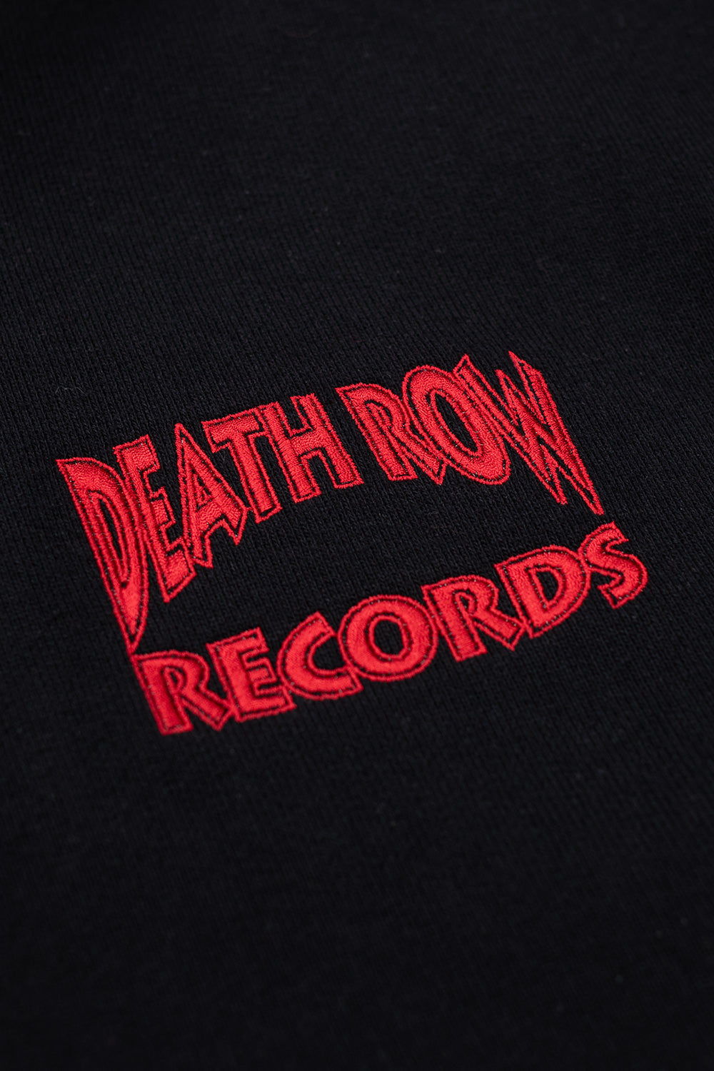 Death Row Records chest embroidery in red on black hoodie, Wacko Maria collaboration streetwear piece inspired by 90s hip hop culture
