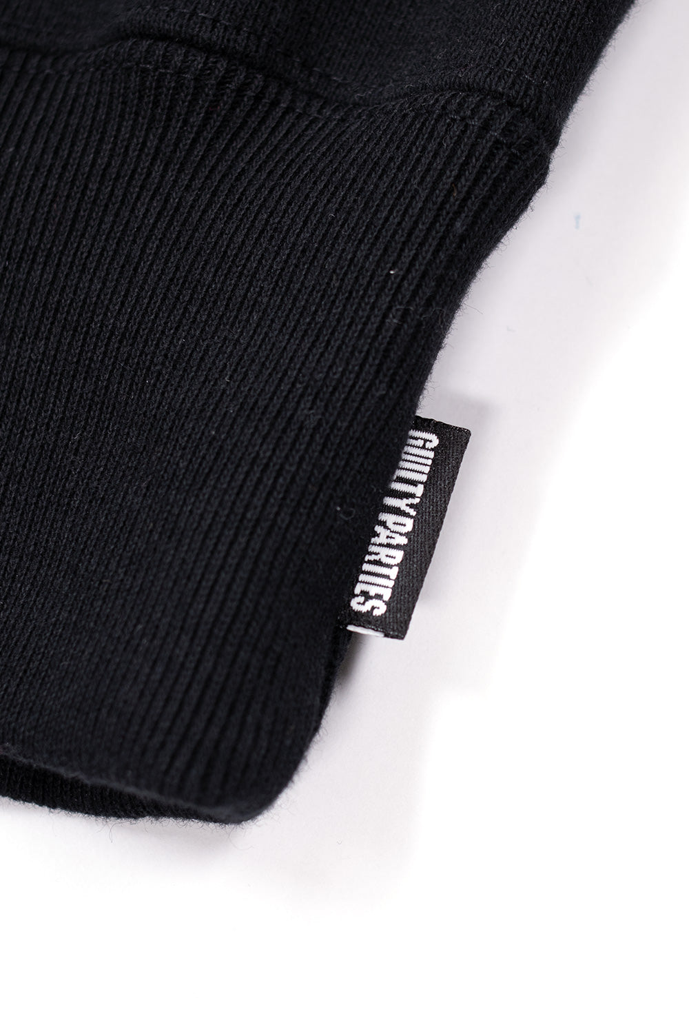 Guilty Parties woven label tag on side seam of Wacko Maria hoodie, authentic Japanese designer streetwear detail in heavyweight cotton